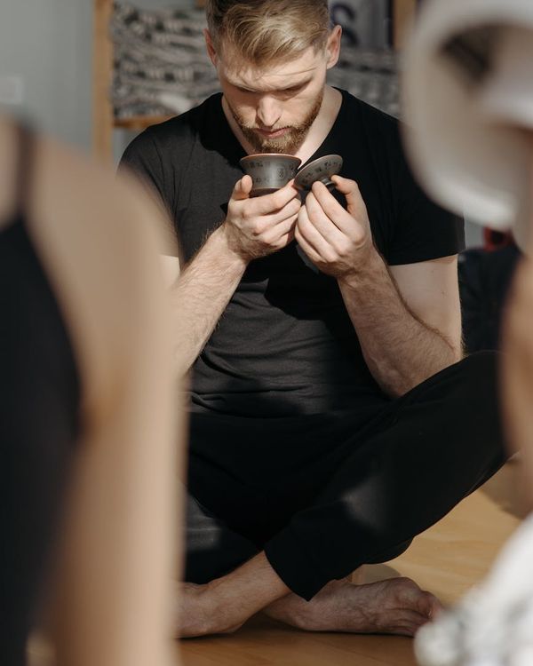 Person meditating peacefully, sitting cross-legged in a softly lit environment.